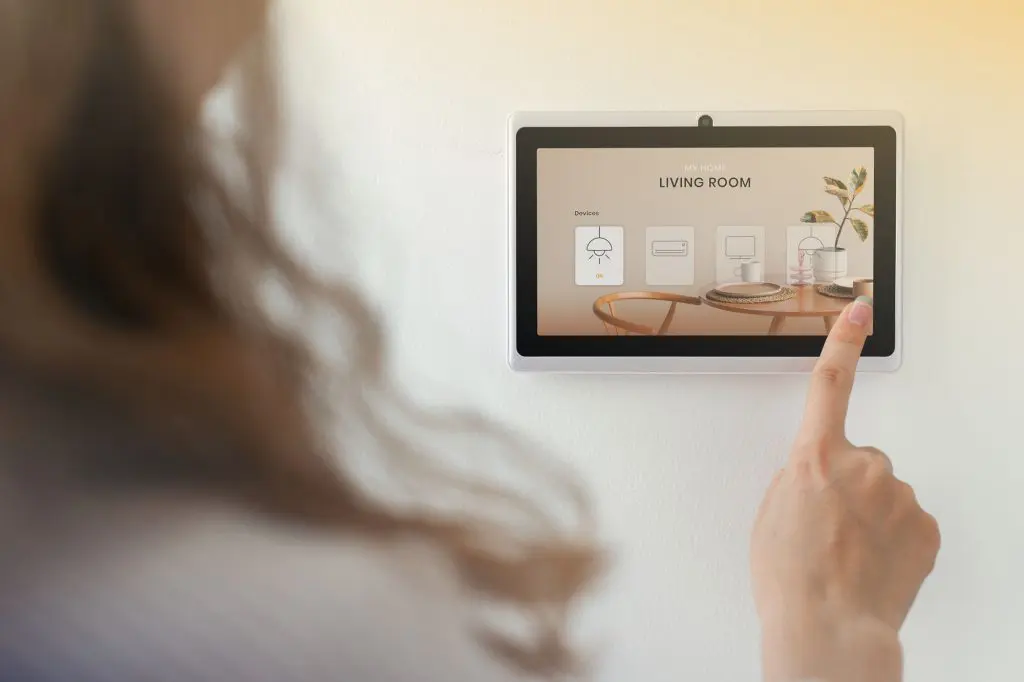 Smart home technology with woman using control panel to set up accessibility features.