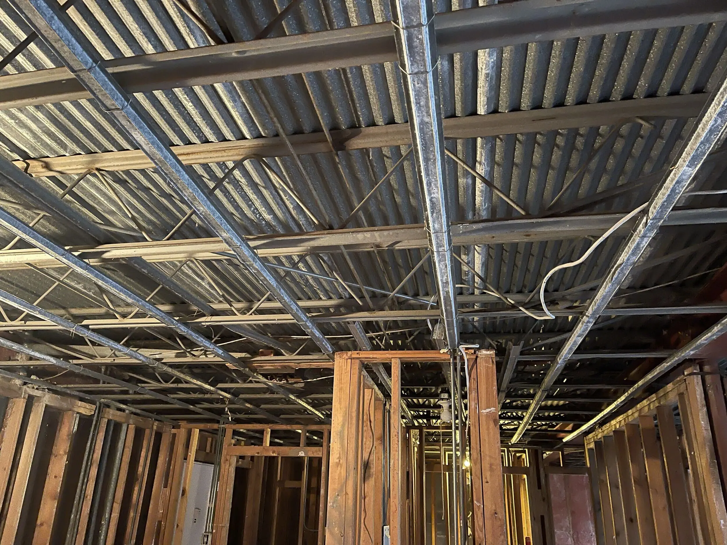 Ceiling removed, exposing steel joists and metal deck