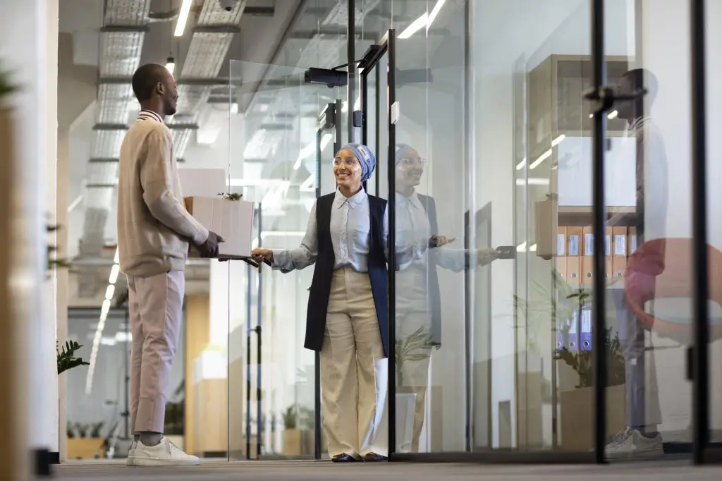 A man speaks to his boss outside of her office in a newly renovated Chicago office.