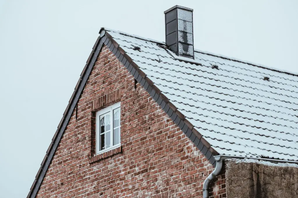 Shot of the roof of a vintage Chicago home covered in snow in the winter.